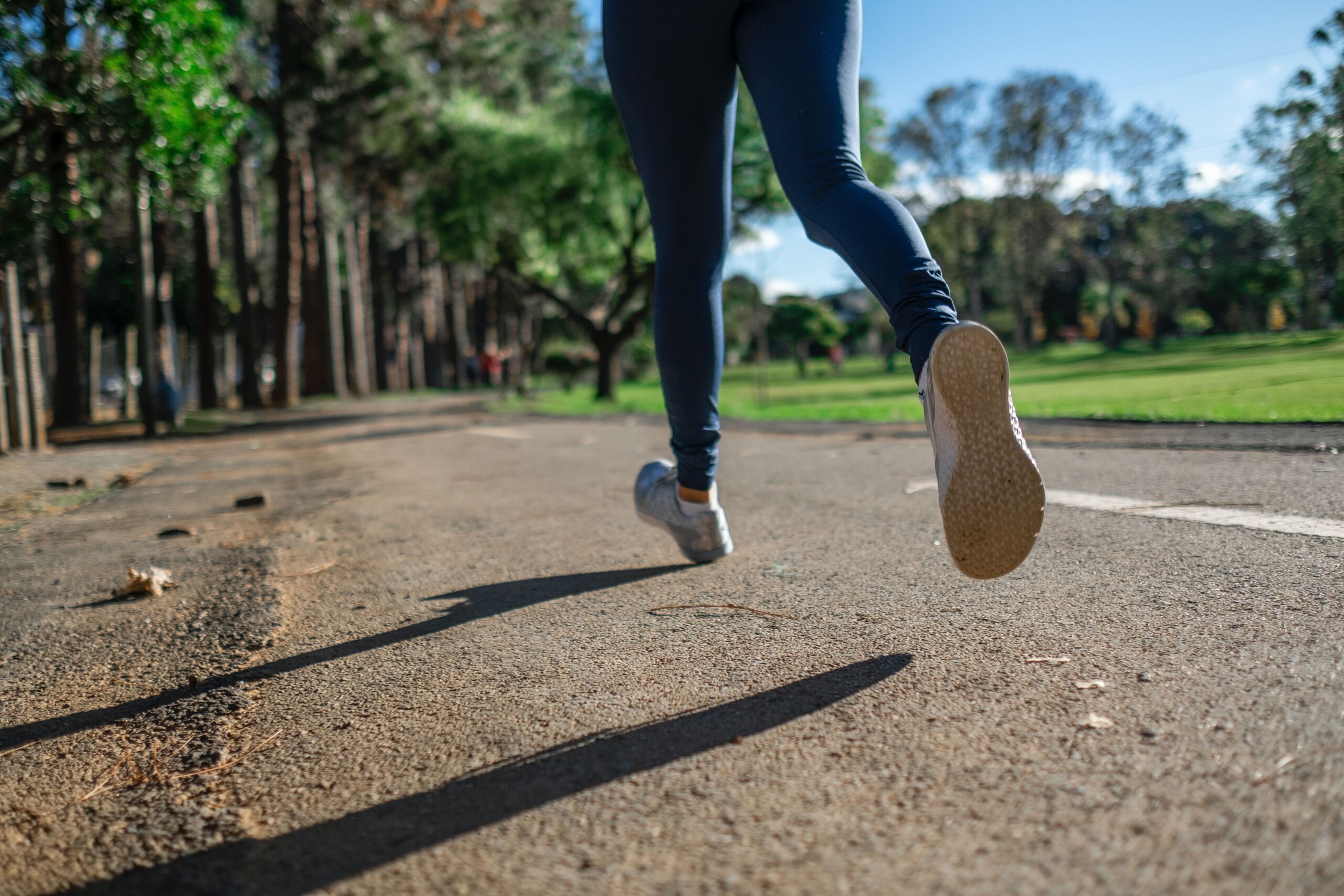 woman jogging in a park, only her legs are showing