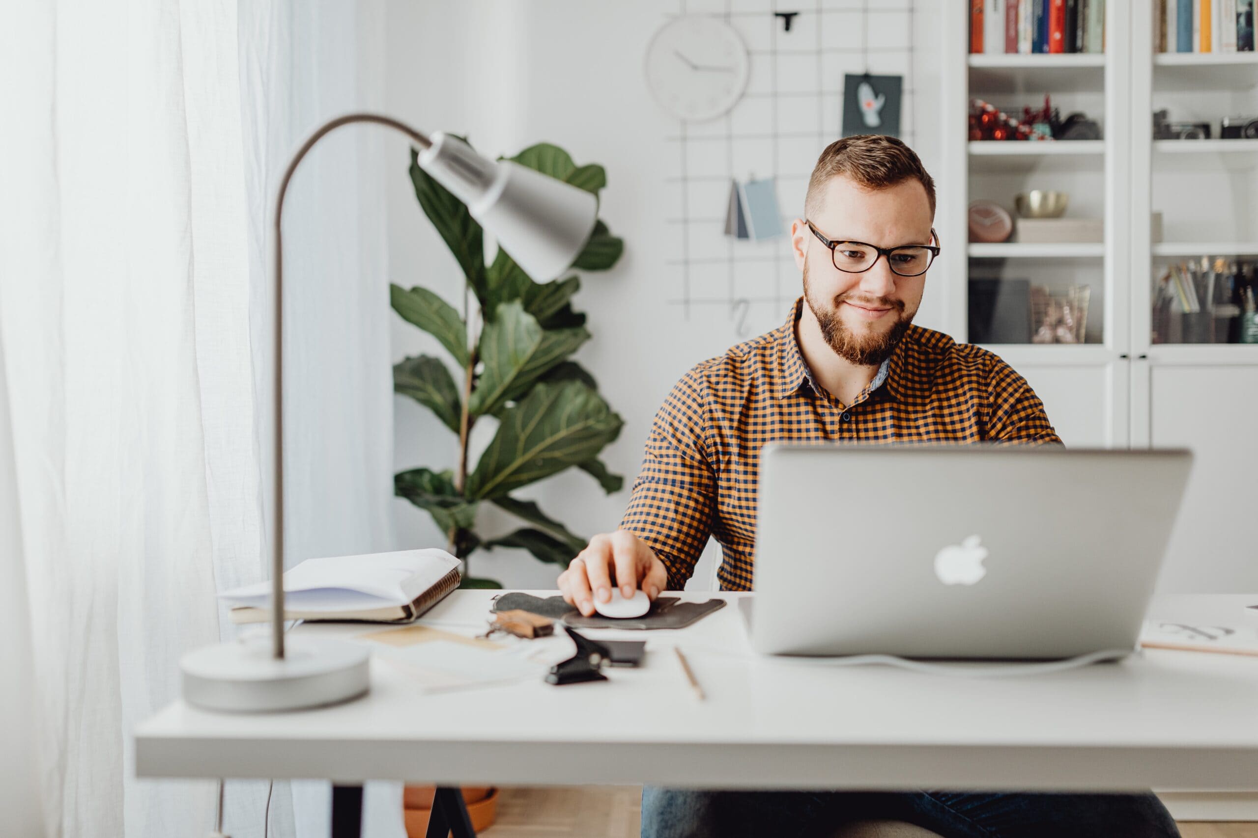 man sitting behind a desk working on his laptop