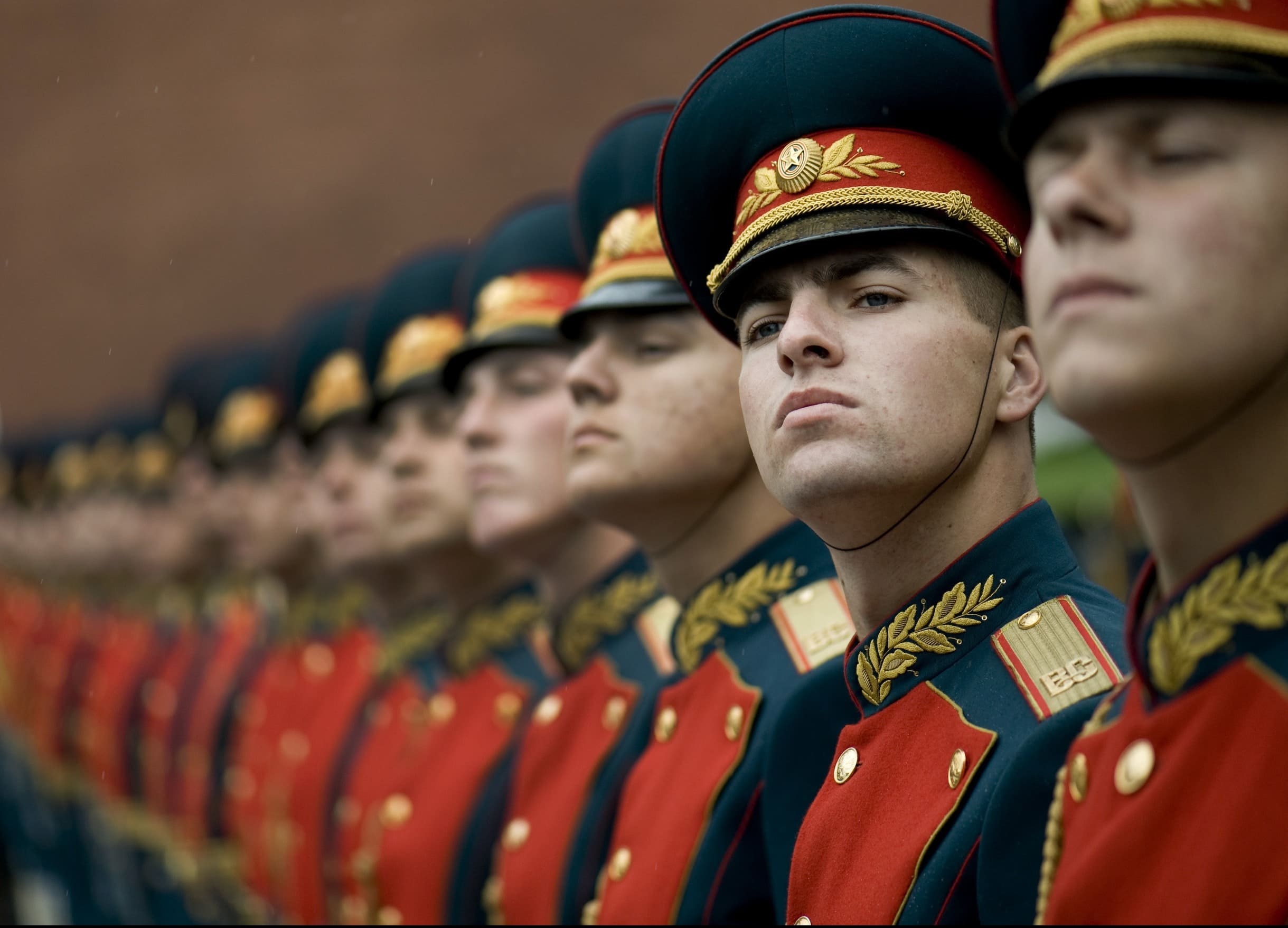 soliders standing in a row, one looking the opposite direction.